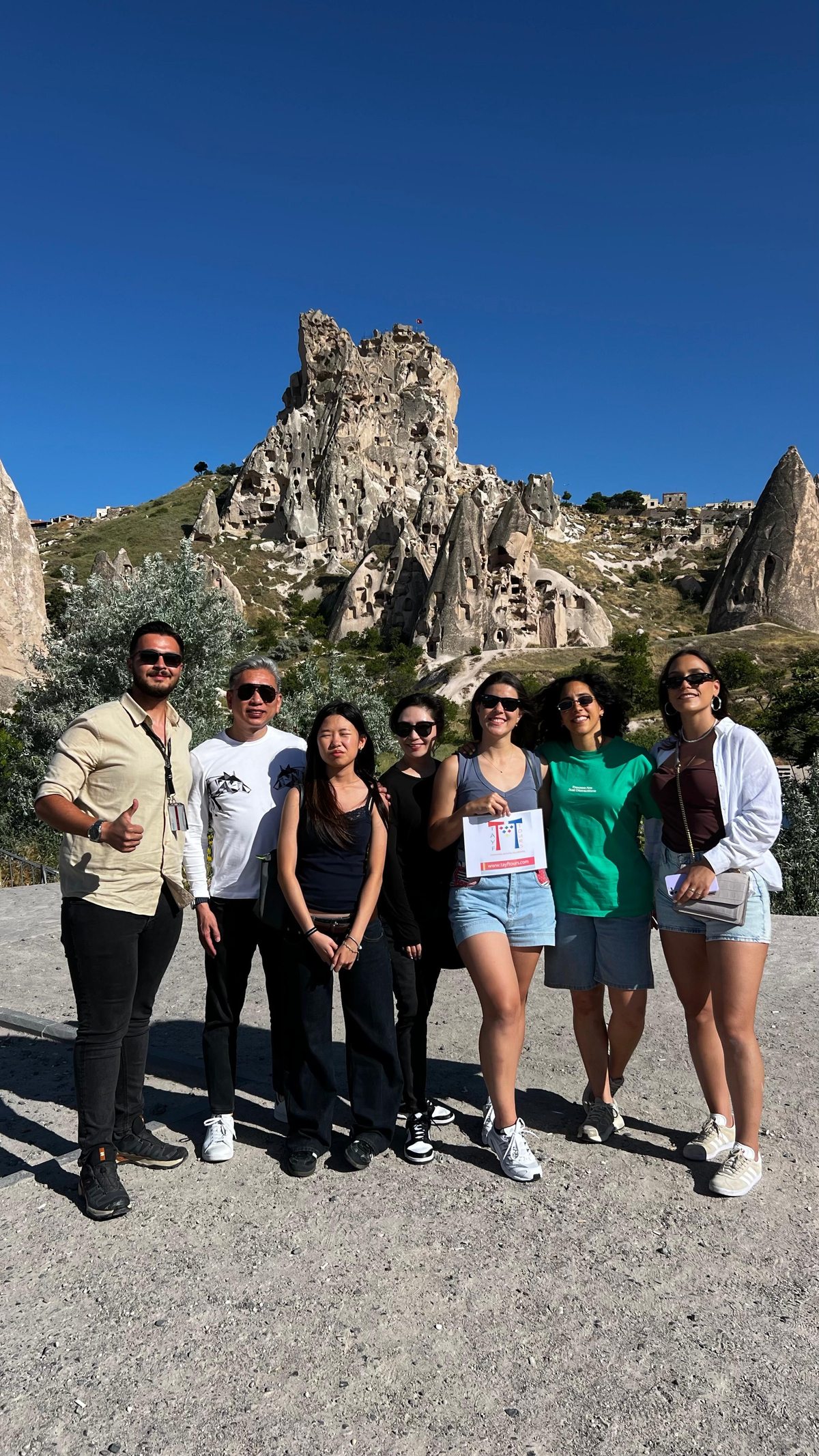 A Tayf Tours guide and travelers in Cappadocia in front of Uchisar Castle