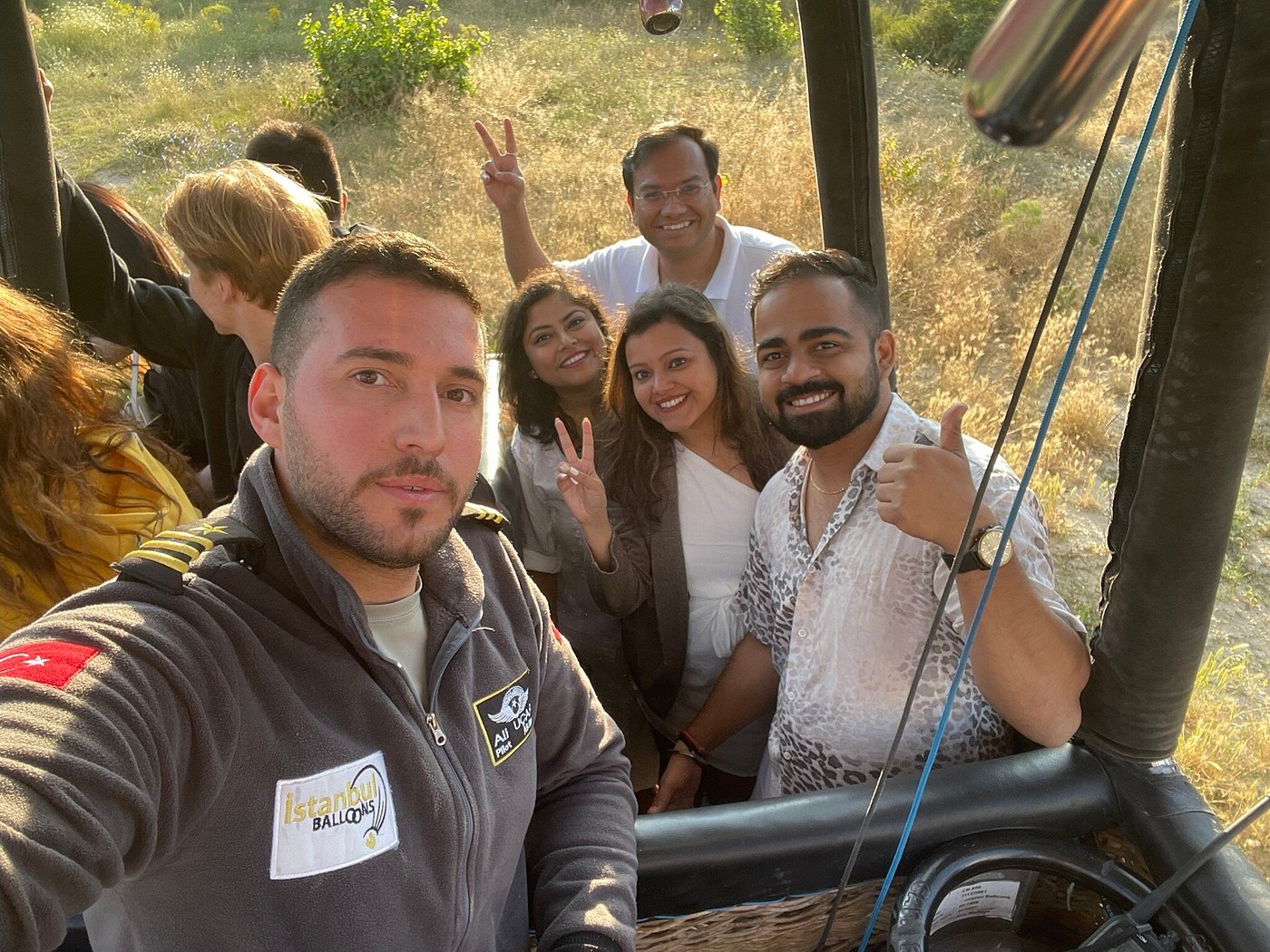 Captain Ali Uçar, licensed Istanbul Balloons pilot, with international guests inside the basket of his hot air balloon in Cappadocia