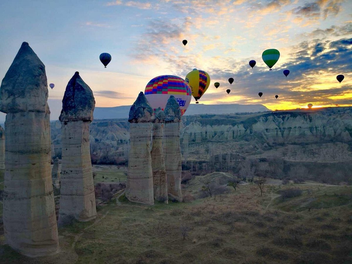 A sunrise scene over Göreme, Cappadocia, with hot air balloons grounded on a weather-cancelled morning